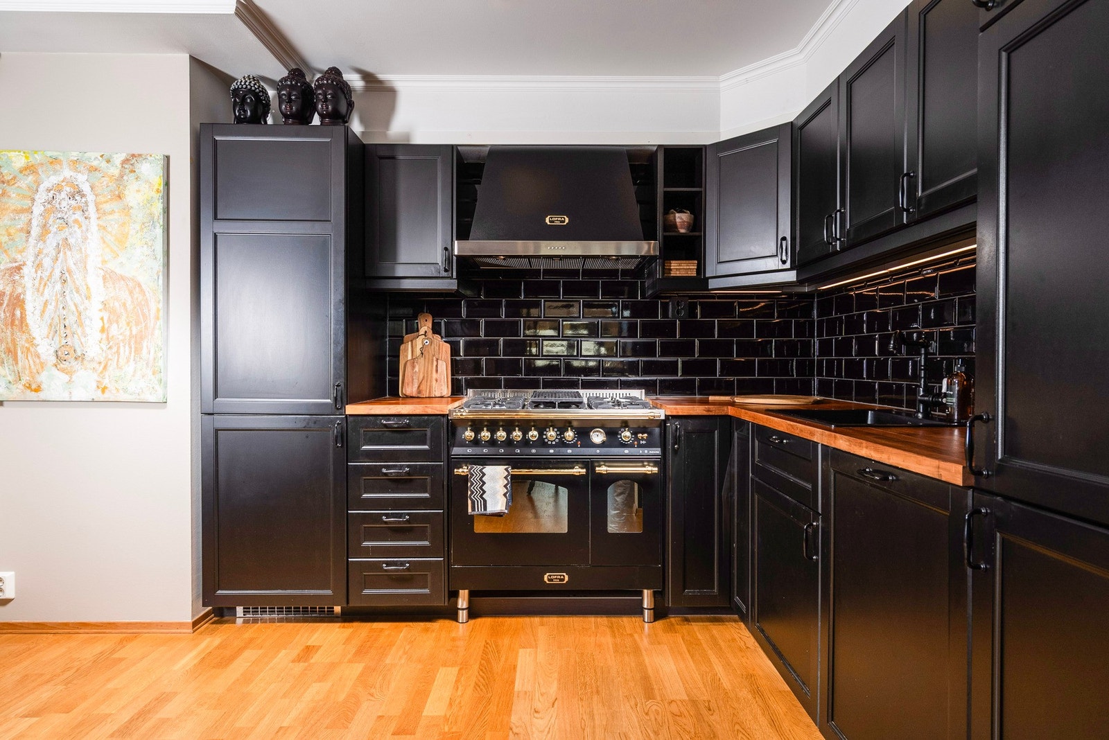 Her har du godt lys fra downlights i taket og lys under overskap - kombinert med fliser på veggen får du et funksjonelt kjøkken med enkelt renhold og et moderne uttrykk Galleribilde