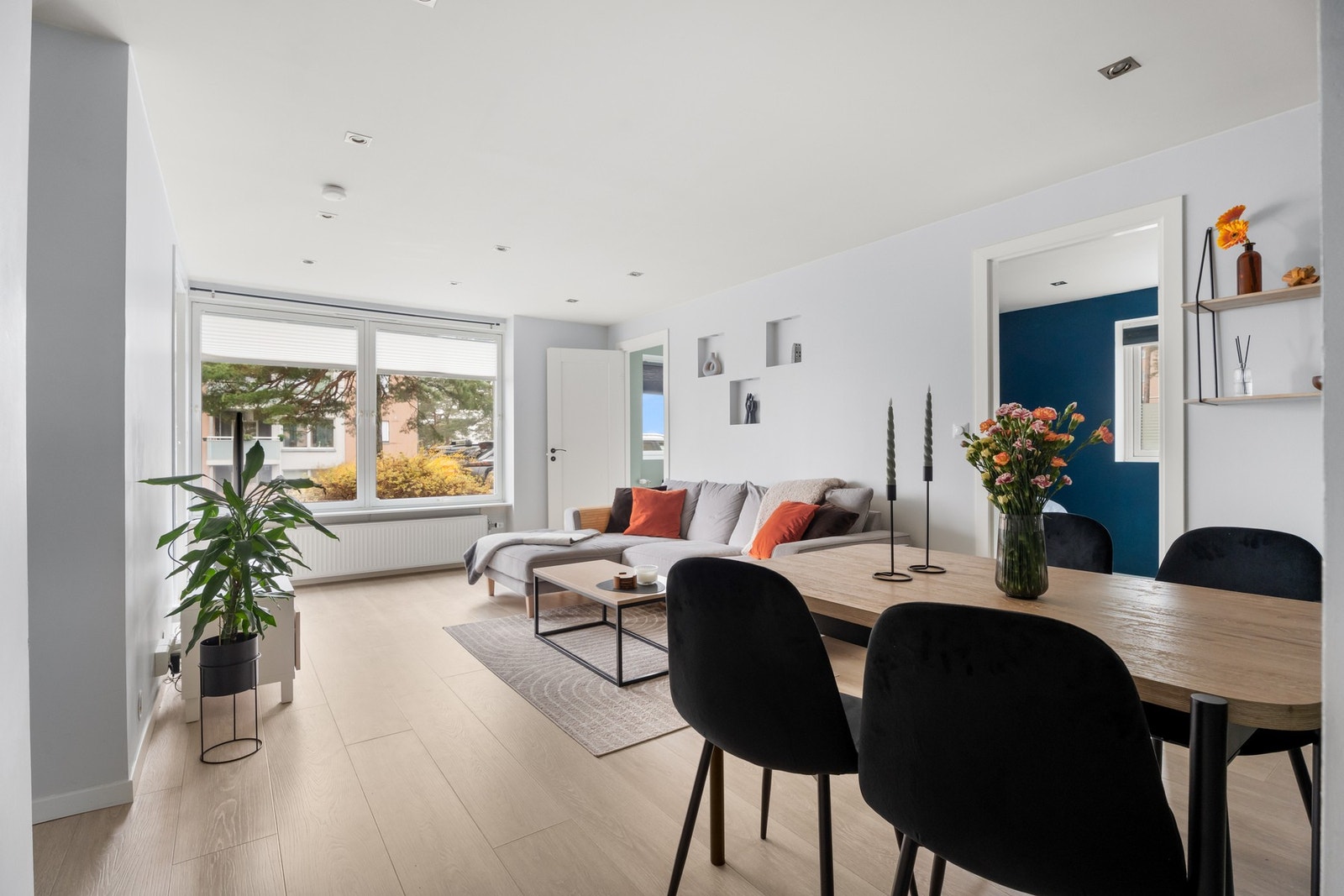 Stue med laminatgulv og store vindusoverflater. Galleribilde