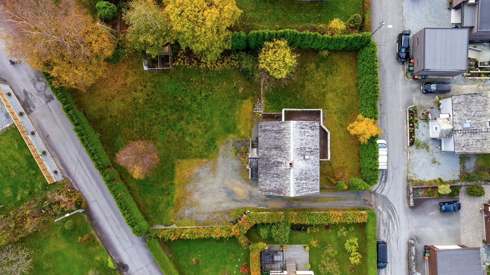 Eiendommen ligger i relativt flatt terreng og er i dag opparbeidet med gruset innkjørsel og romslig hage Galleribilde