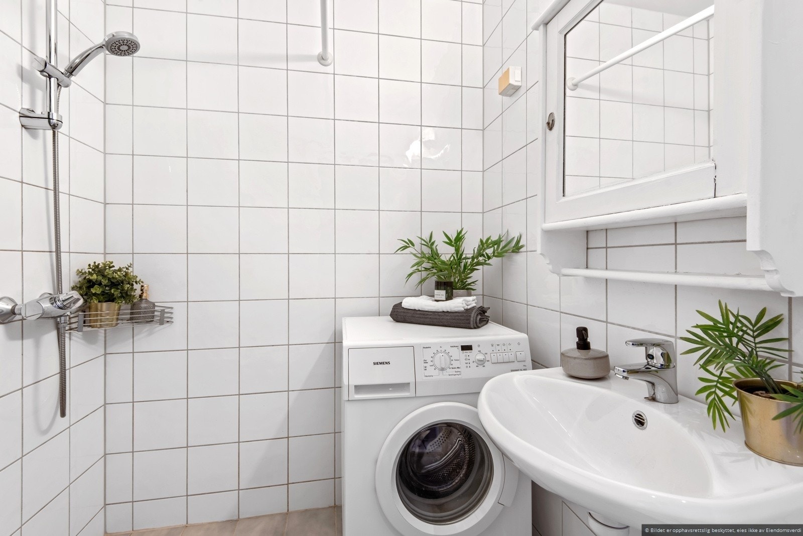 Lyst flislagt bad med plass til vaskemaskin. Galleribilde