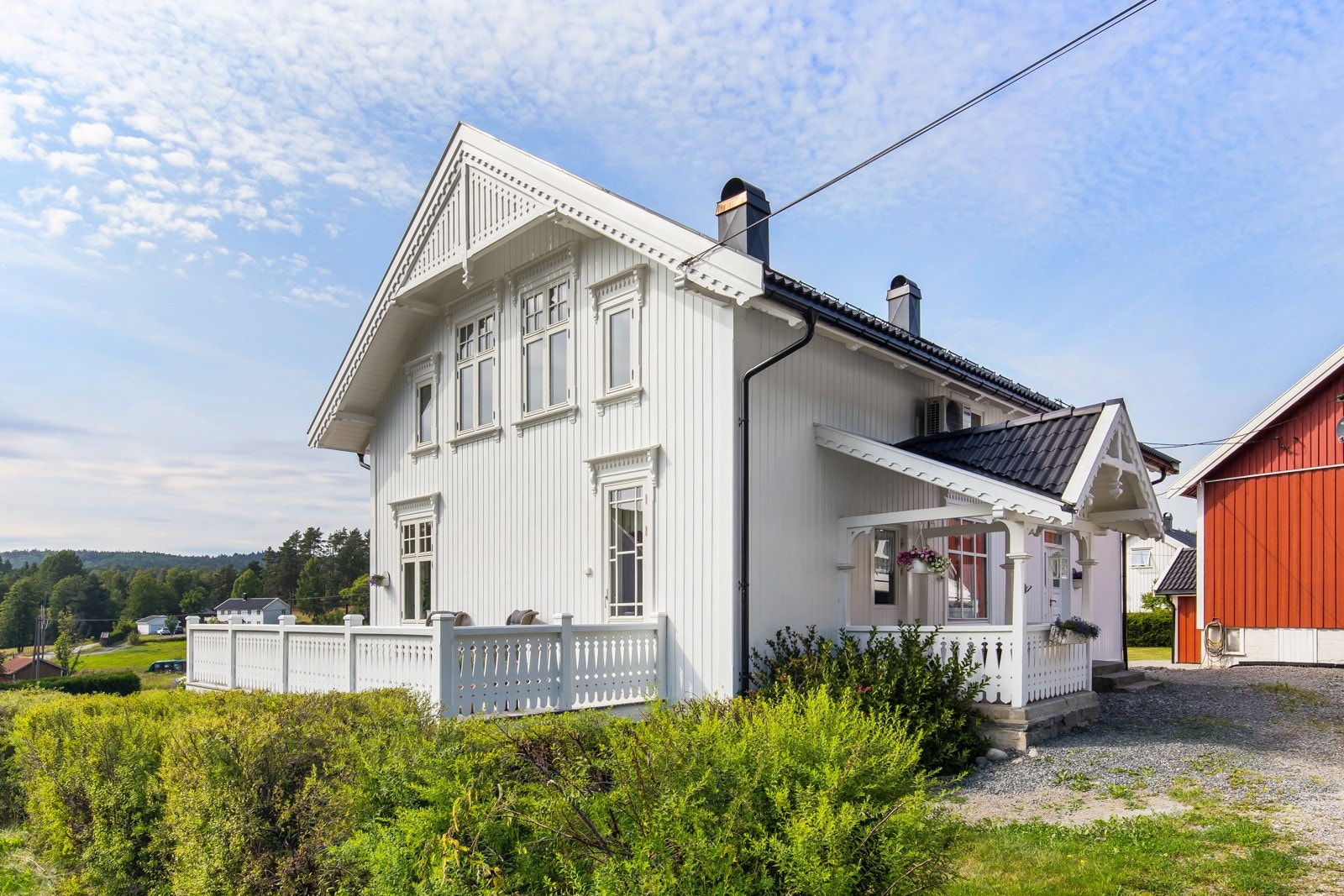 Hvit, tradisjonell bolig med stor veranda Galleribilde