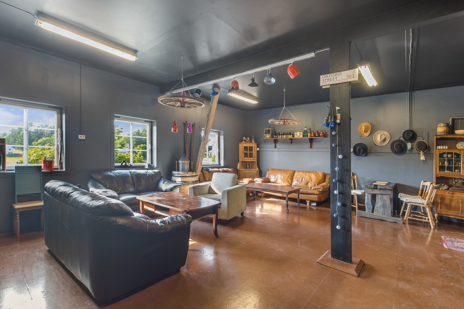 Romslig stue med mørke vegger og gulv. Fire vinduer gir godt med naturlig lys. Galleribilde