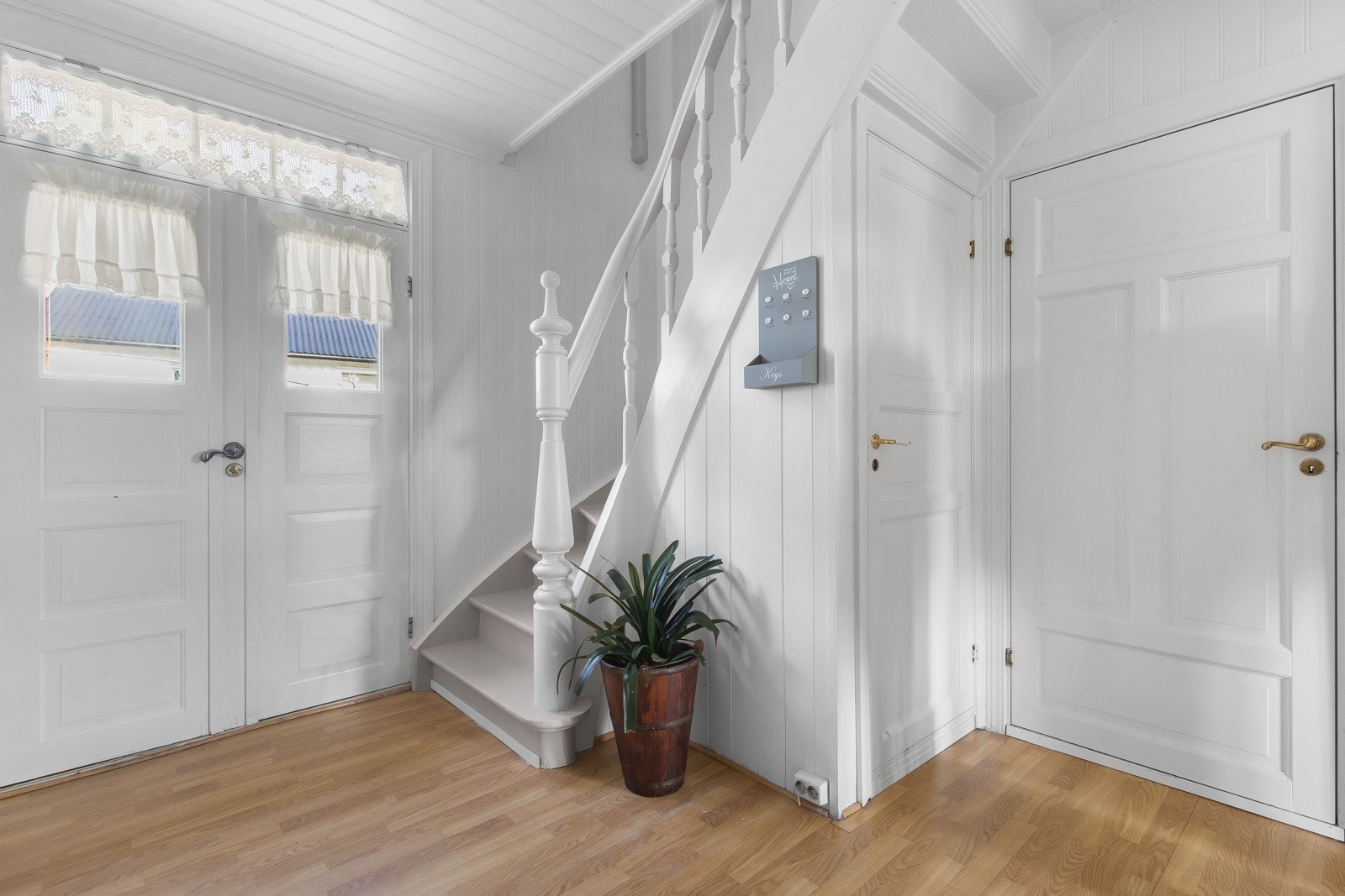 Tofløyet original inngangsdør | Lyst og romslig inngangsparti med hvite vegger og lyse tregulv. Galleribilde