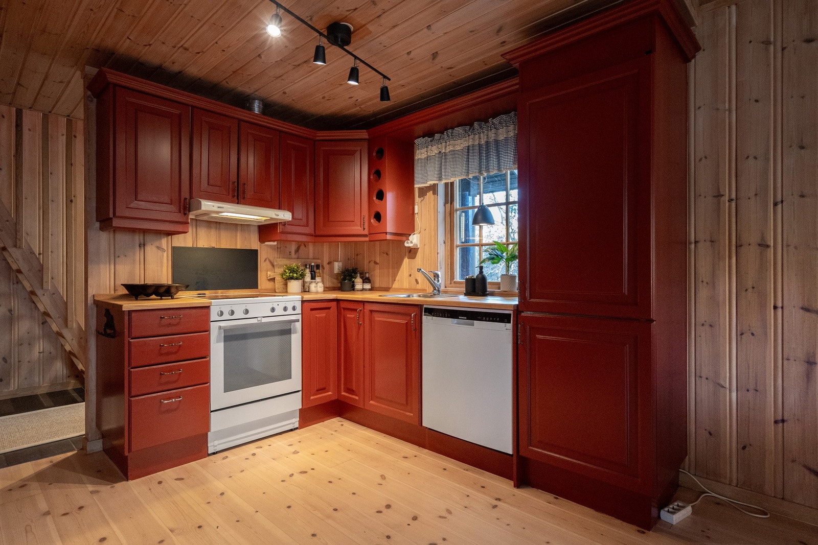 Hytta har et trivelig og praktisk kjøkken med innredning i heltre og rødmalte profilerte fronter som står flott til de øvrige materialene i hytta. Galleribilde