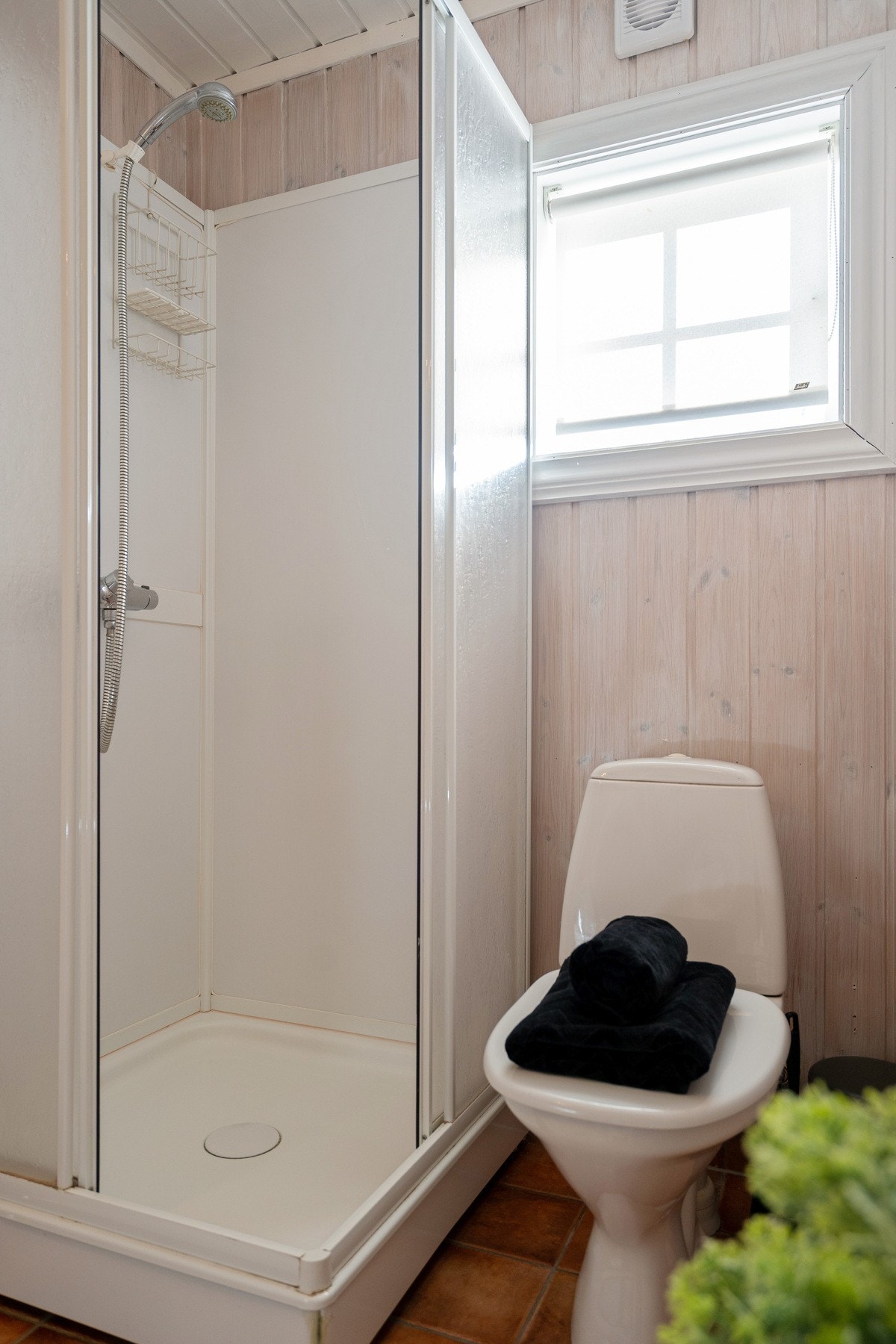 Badet er utstyrt med dusjkabinett og gulvmontert toalett. Galleribilde