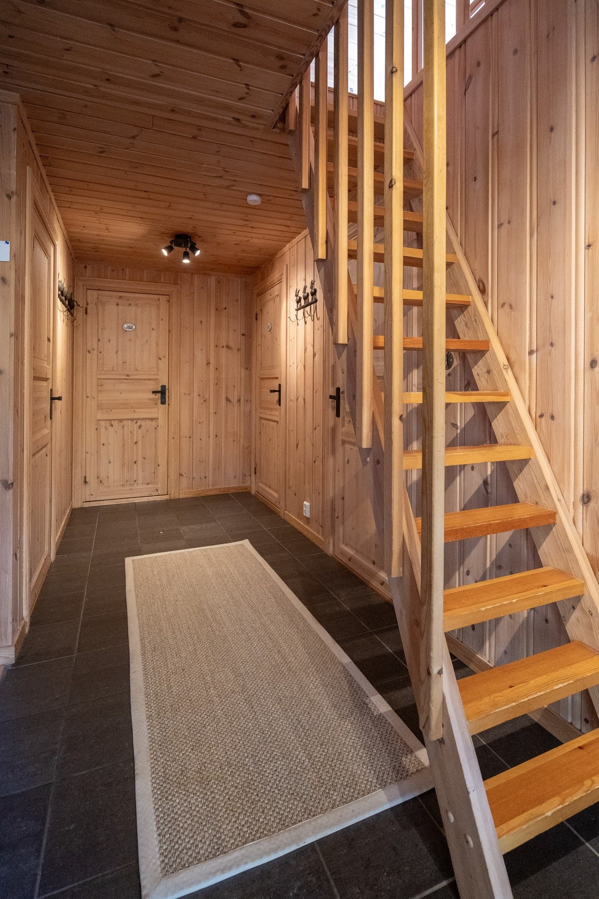 Romslig gang med trapp opp til hems, og god plass til yttertøy og sko. Galleribilde