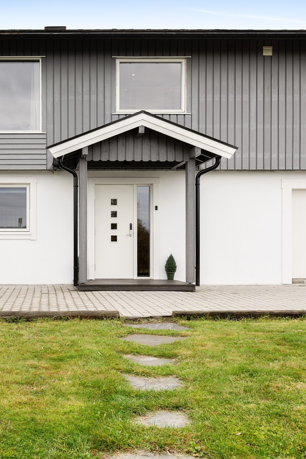 Du ønskes velkommen inn via et hyggelig overbygget inngangsparti. Ytterdør fra 2017 med glassfelt og praktisk kodelås er montert. Galleribilde