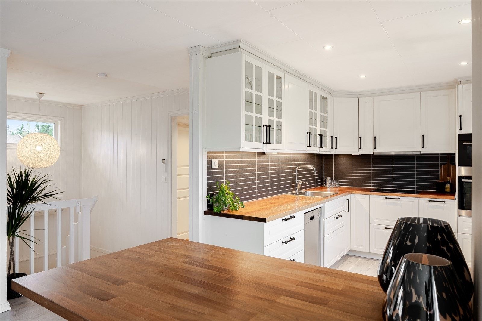 Kjøkkenet har en praktisk utforming med en kjøkkenøy som sørger for ekstra god skap- og benkeplass, samt en hyggelig sitteplass med barstoler. Galleribilde