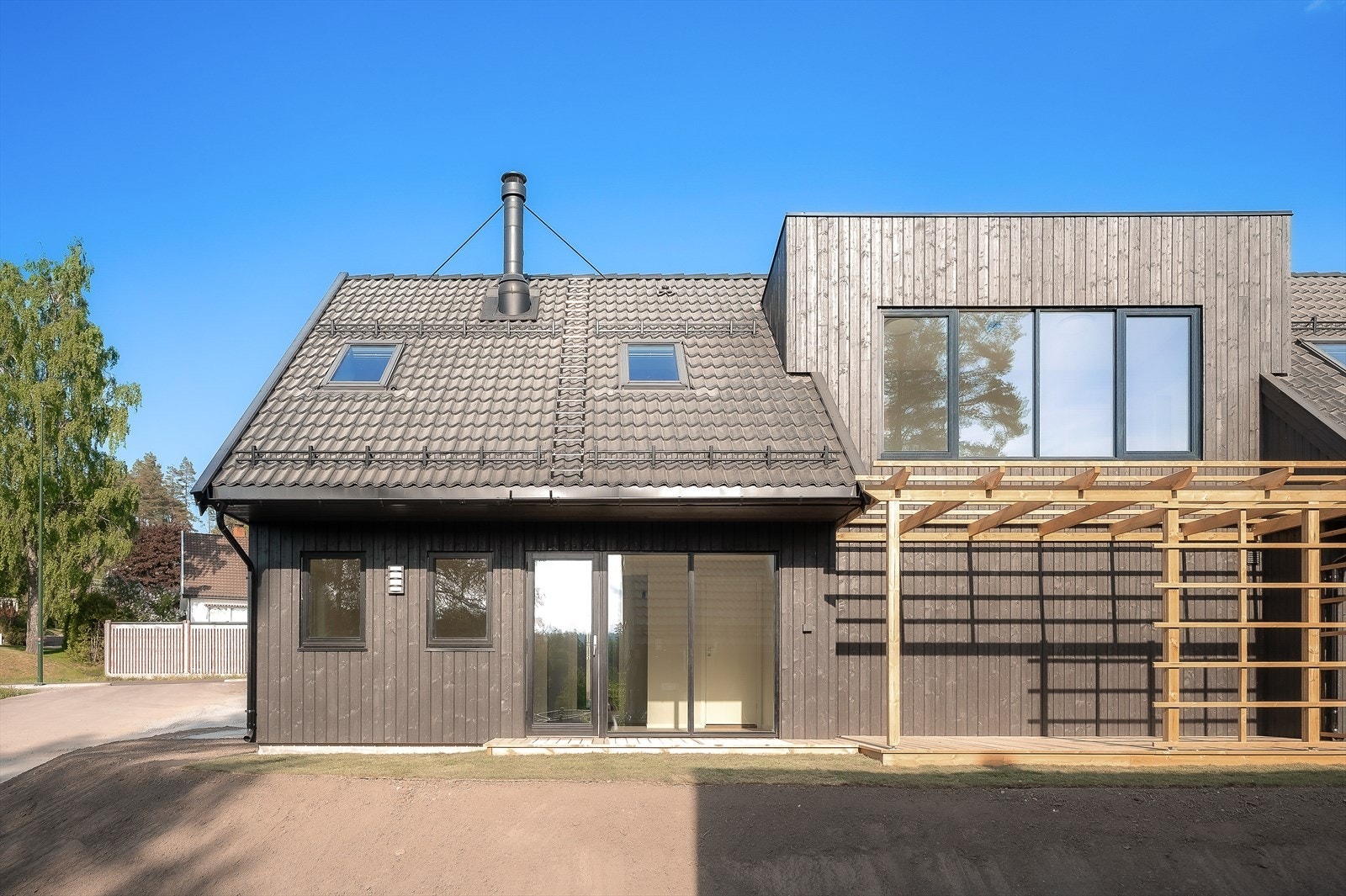 Sommerbilde før uteområdene ble ferdig opparbeidet med gress og beplantning (NB! Bilde er av bolig D som er identisk som B) Galleribilde