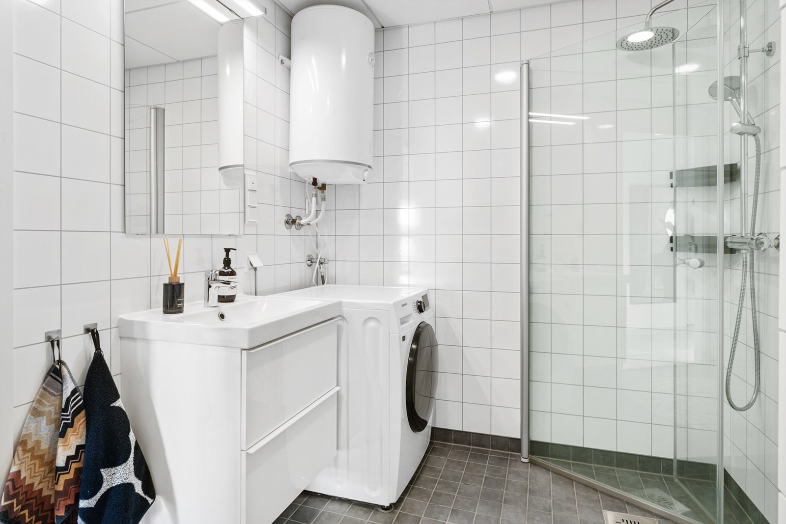 Romslig bad med innfellbare dusjdører og lys innredning Galleribilde