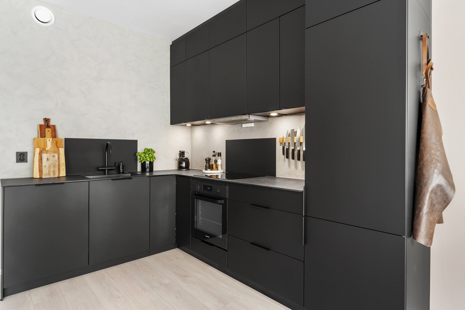Smakfullt kjøkken med sort innredning og rikelig skapplass. Galleribilde