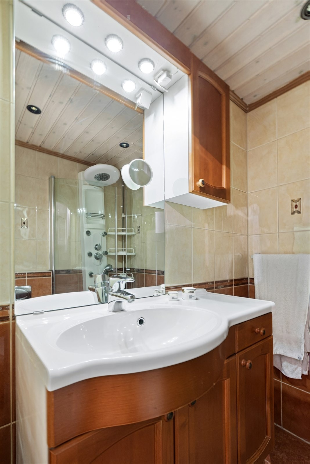 Badet er innredet med servantinnredning, dusjhjørne og vegghengt toalett. Galleribilde