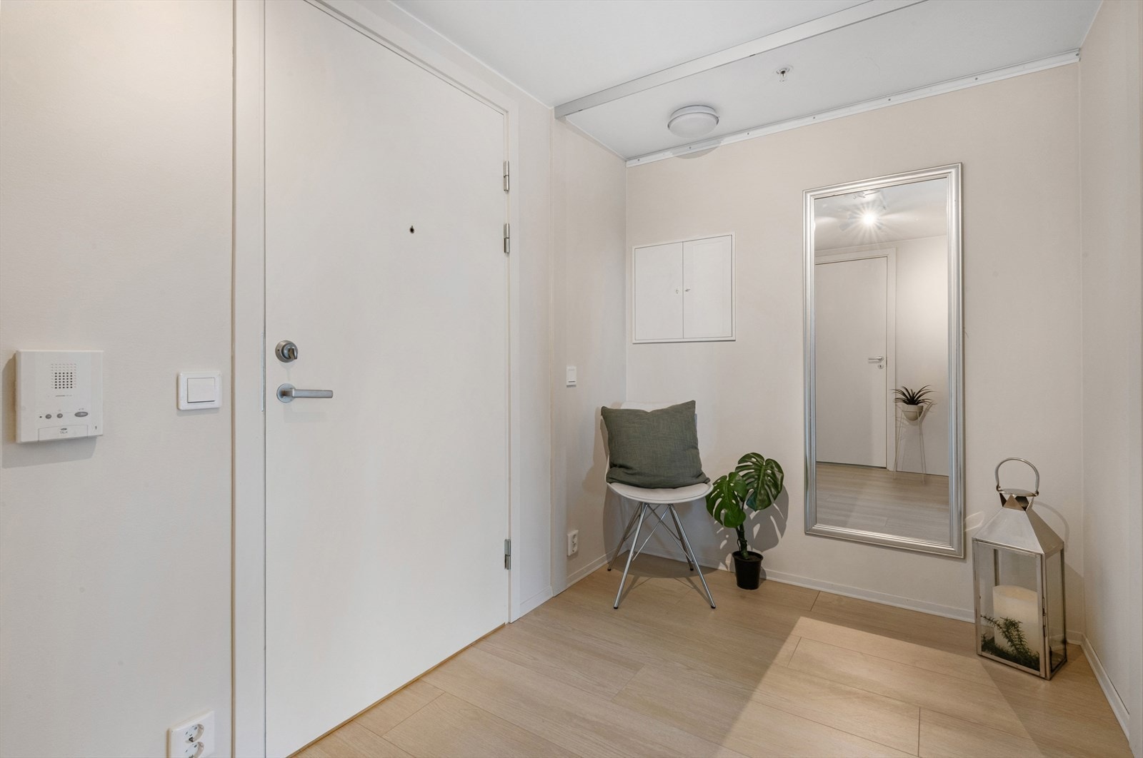Lys og innbydende entré som gir et godt førsteinntrykk av leiligheten. Her er det god plass til å henge fra seg yttertøy og sko i en praktisk skyvedørsgarderobe med speil. Galleribilde