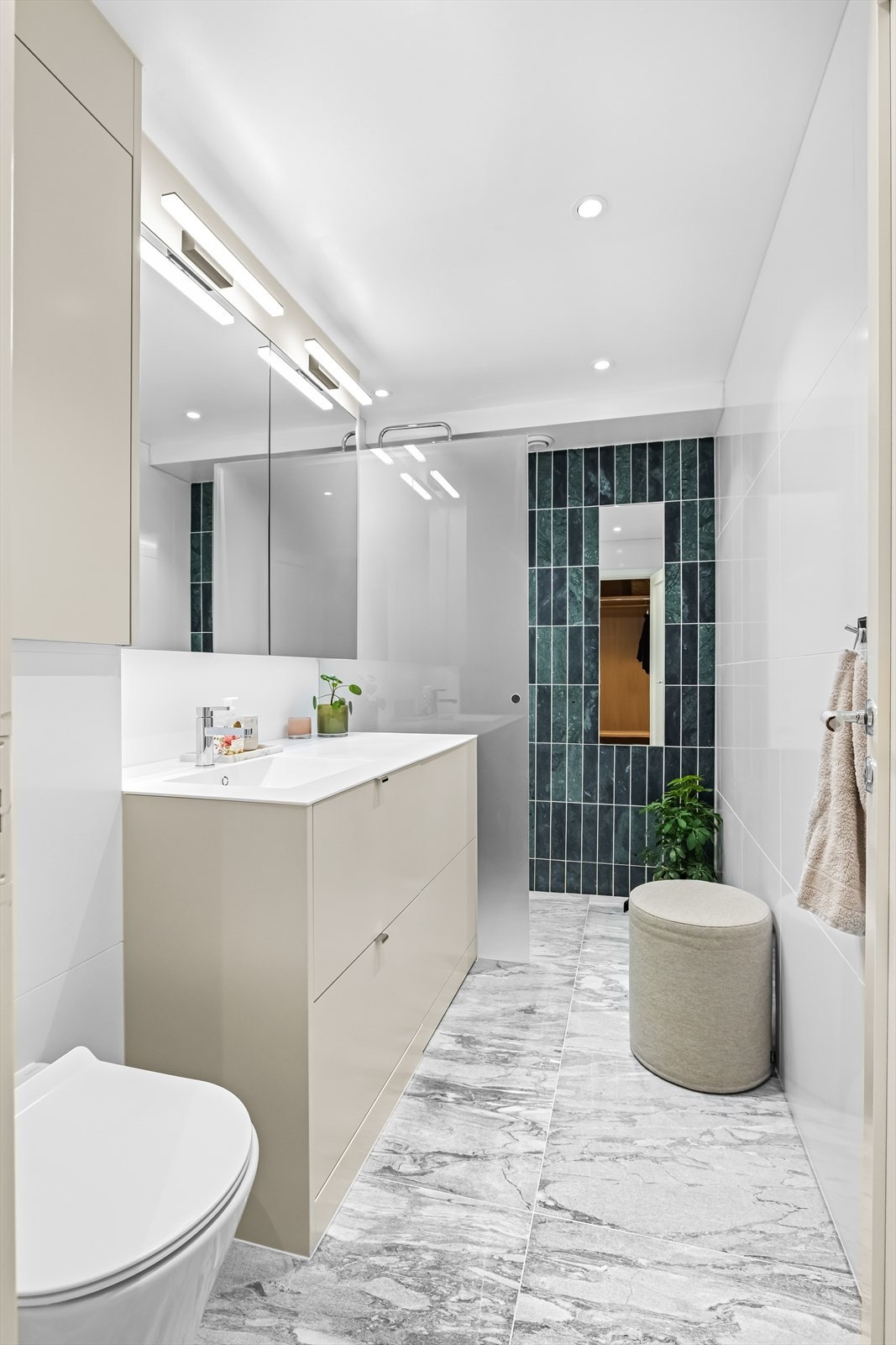 Delikat baderom med mye skapplas og lekre fliser Galleribilde