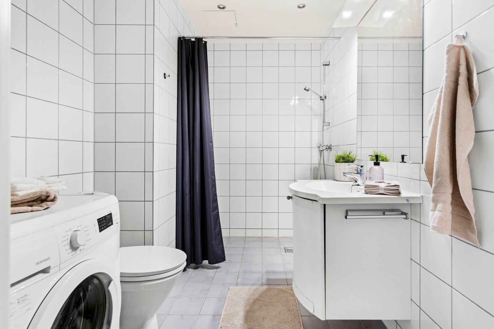 Flislagt baderom med behagelig gulvvarme og opplegg for vaskemaskin. Galleribilde
