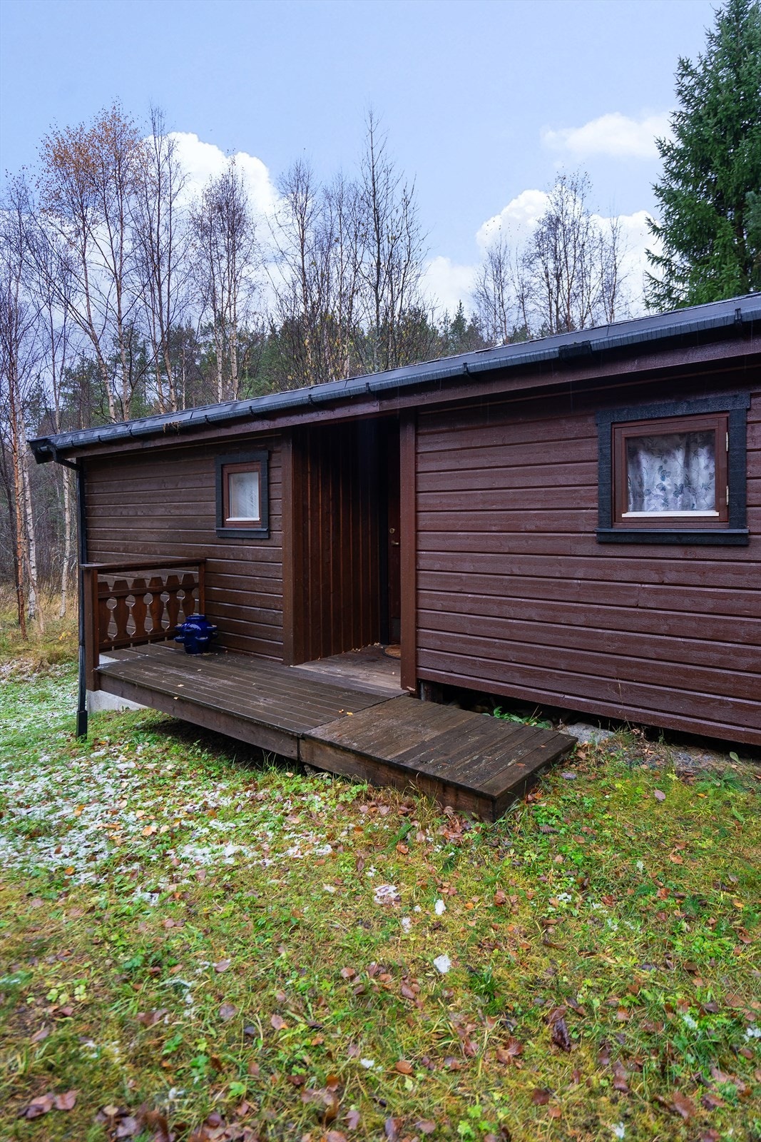 Anneksbygningen har en liten veranda foran inngangsdøren og ligger tett inntil skogen, med fredelige omgivelser og god skjerming Galleribilde