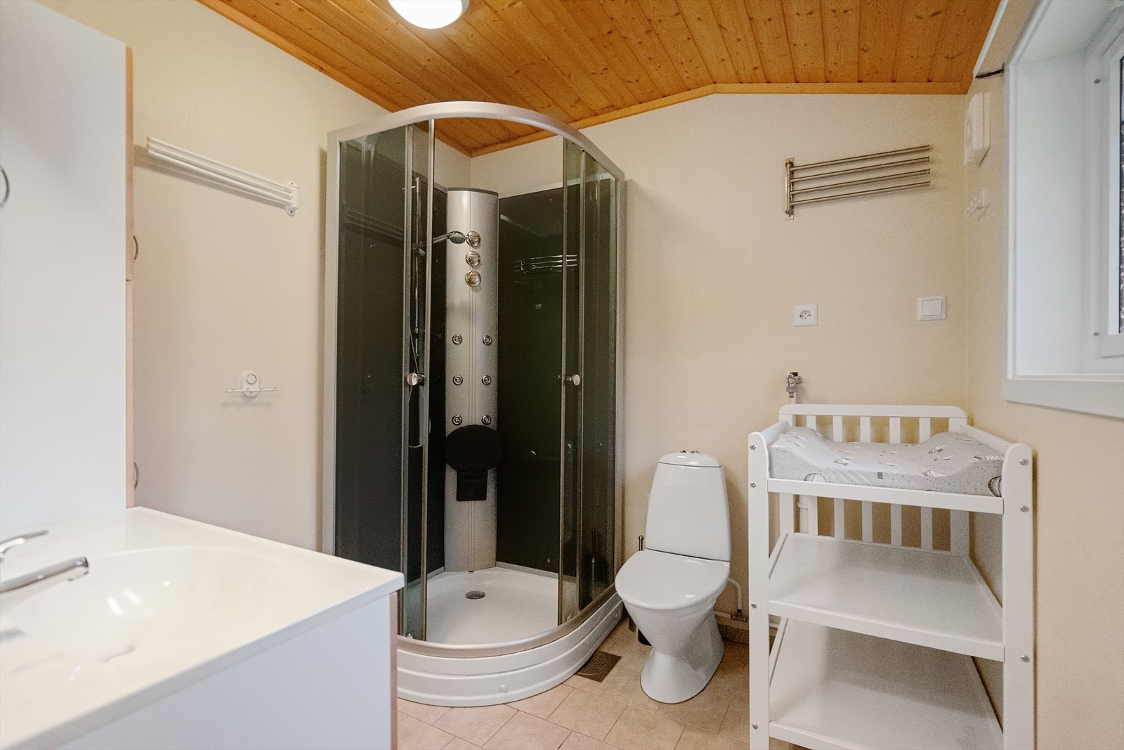 Komplett bad med dusjhjørne, toalett og servant. Et komfortabelt rom som gjør oppholdet enkelt, også for større familier eller gjester Galleribilde