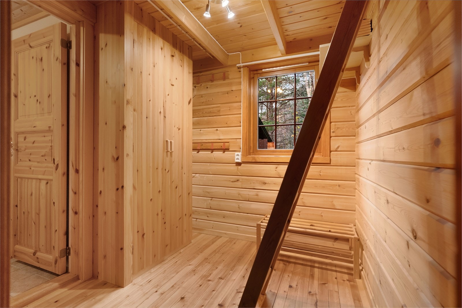 Klassisk hyttepreg med tømmerpanel og varme toner i treverket. Her får du en lun atmosfære fra første steg inn døren Galleribilde