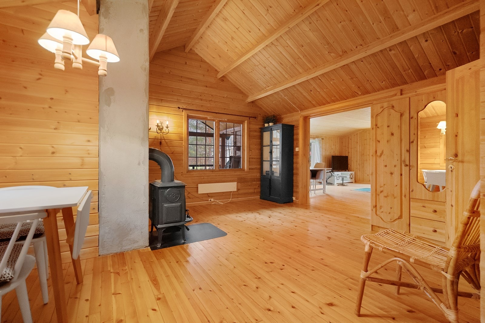 Sjarmerende spisestue med utsikt mot naturen utenfor. Her nytes måltidene i hyggelige omgivelser, med sprakende ild i ovnen rett ved Galleribilde