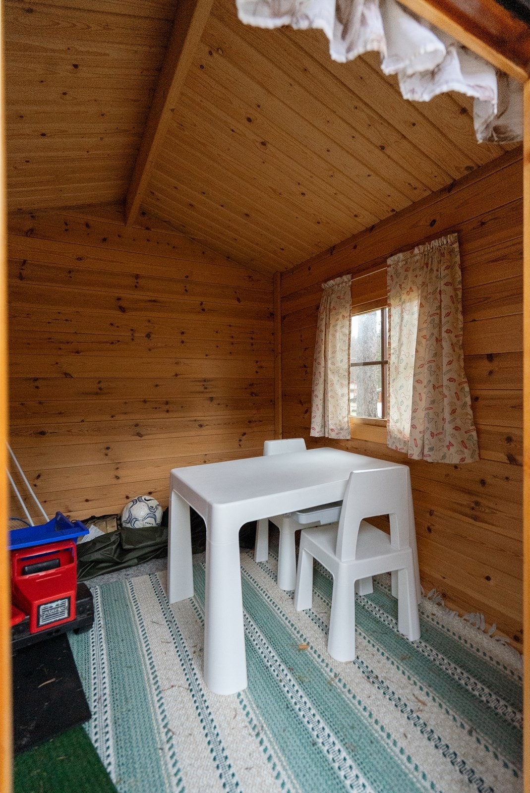 Innbydende og lun lekestue med panelte vegger og vinduer som slipper inn naturlig lys Galleribilde