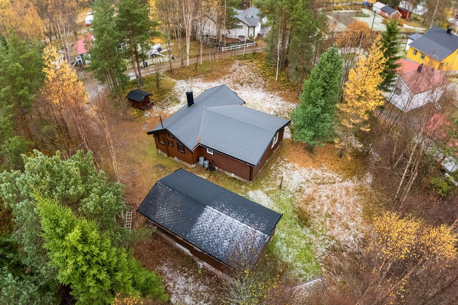 Et helhetlig og innbydende tun med hovedhytte, anneks, vedbod og lekestue - alt praktisk plassert på den romslige tomten Galleribilde