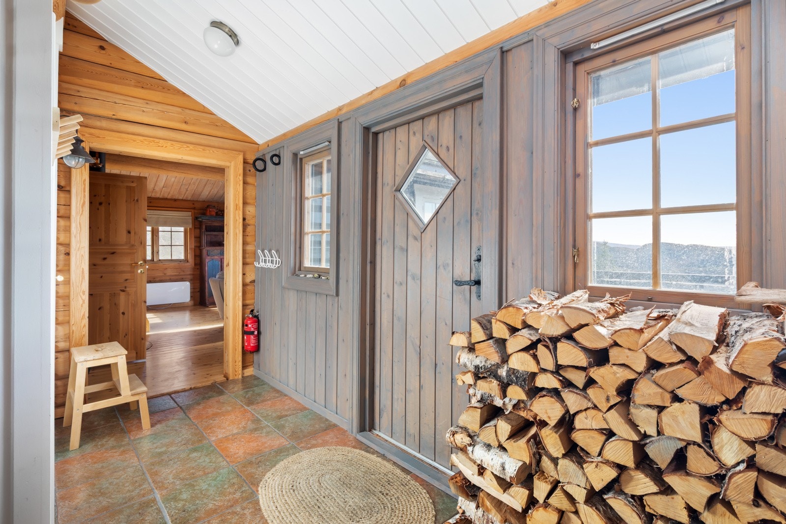 Flislagt gang i midten av hytta. Galleribilde