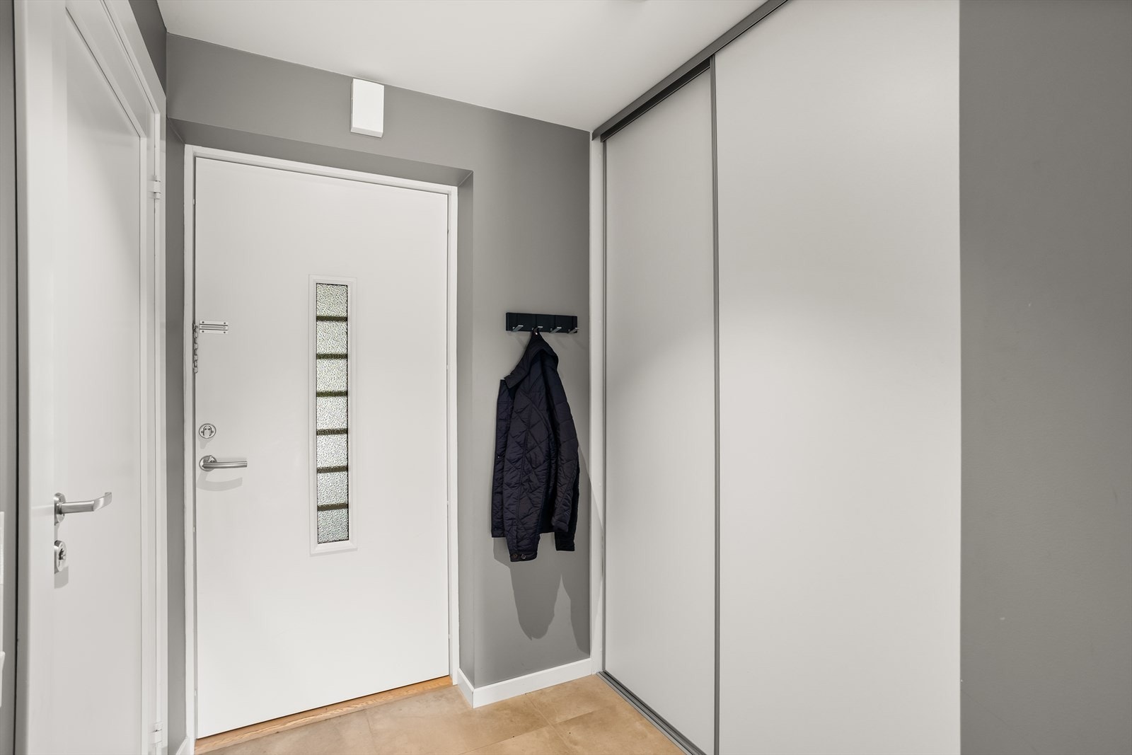 Boligens entré ønsker deg velkommen med flislagt gulv med gulvvarme, noe som er både praktisk og komfortabelt. Galleribilde