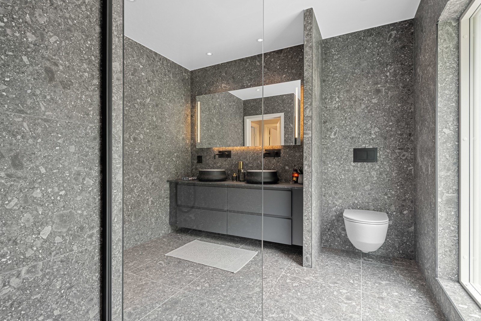 Moderne fliser på gulv og vegger samt dobbel servantinnredning Galleribilde