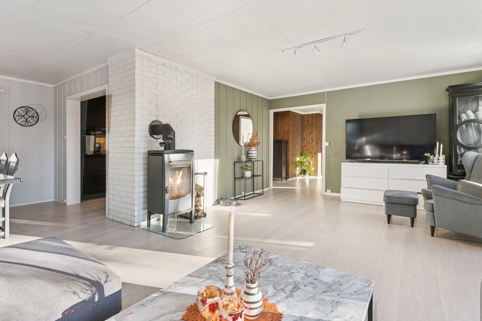 Stuen er et romslig vinkelrom med en vedovn fra 2021 som gir god varme. Galleribilde