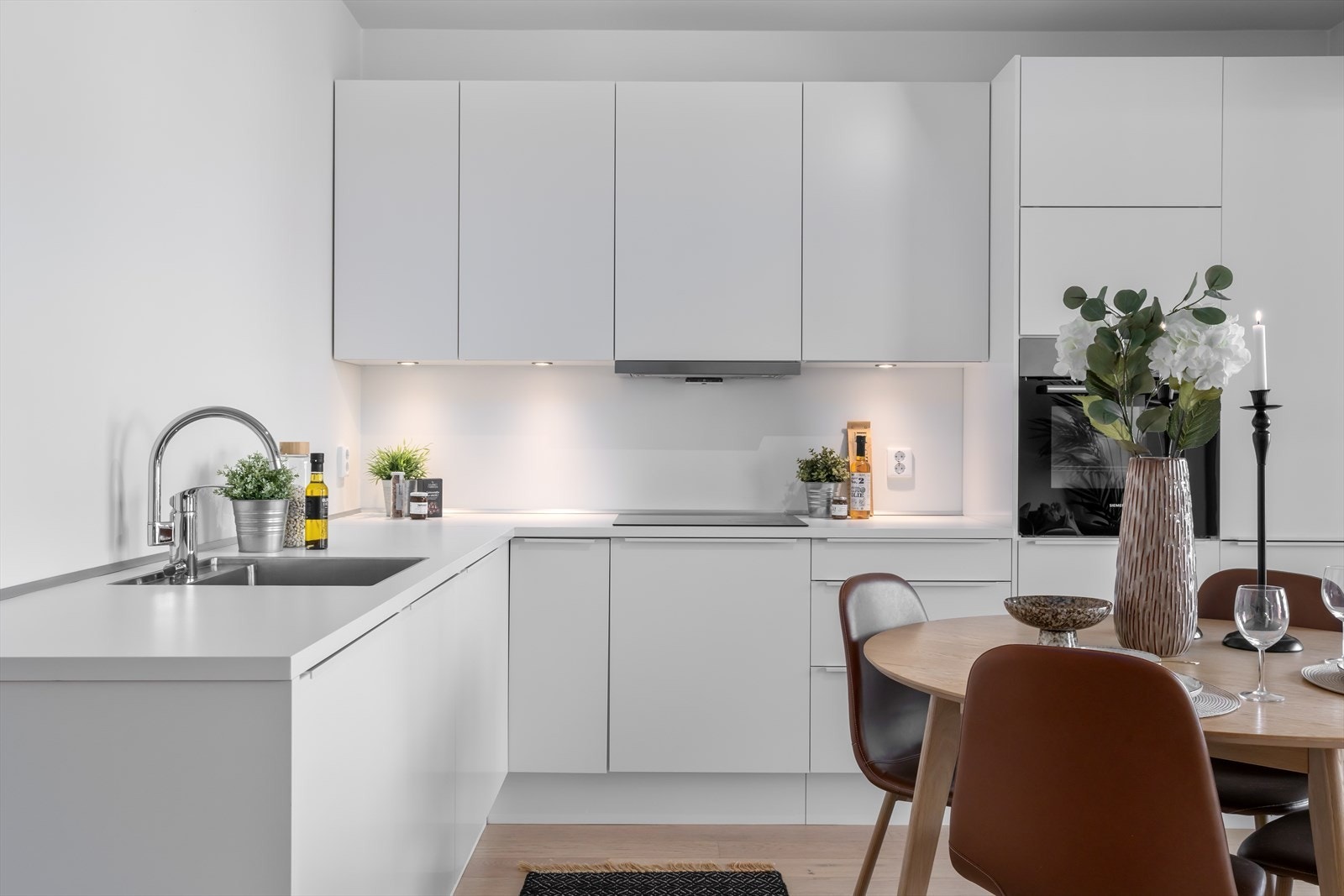 Kjøkkenet har godt med skap-/benkeplass med innredning i hvit utførelse med lyse og delikate fronter fra danske Svanekjøkkenet. Det ler agt vekt på detaljer som gir et pent tilpasset preg og godt med benkeplater som matcher øvrige interiørfarger. Galleribilde