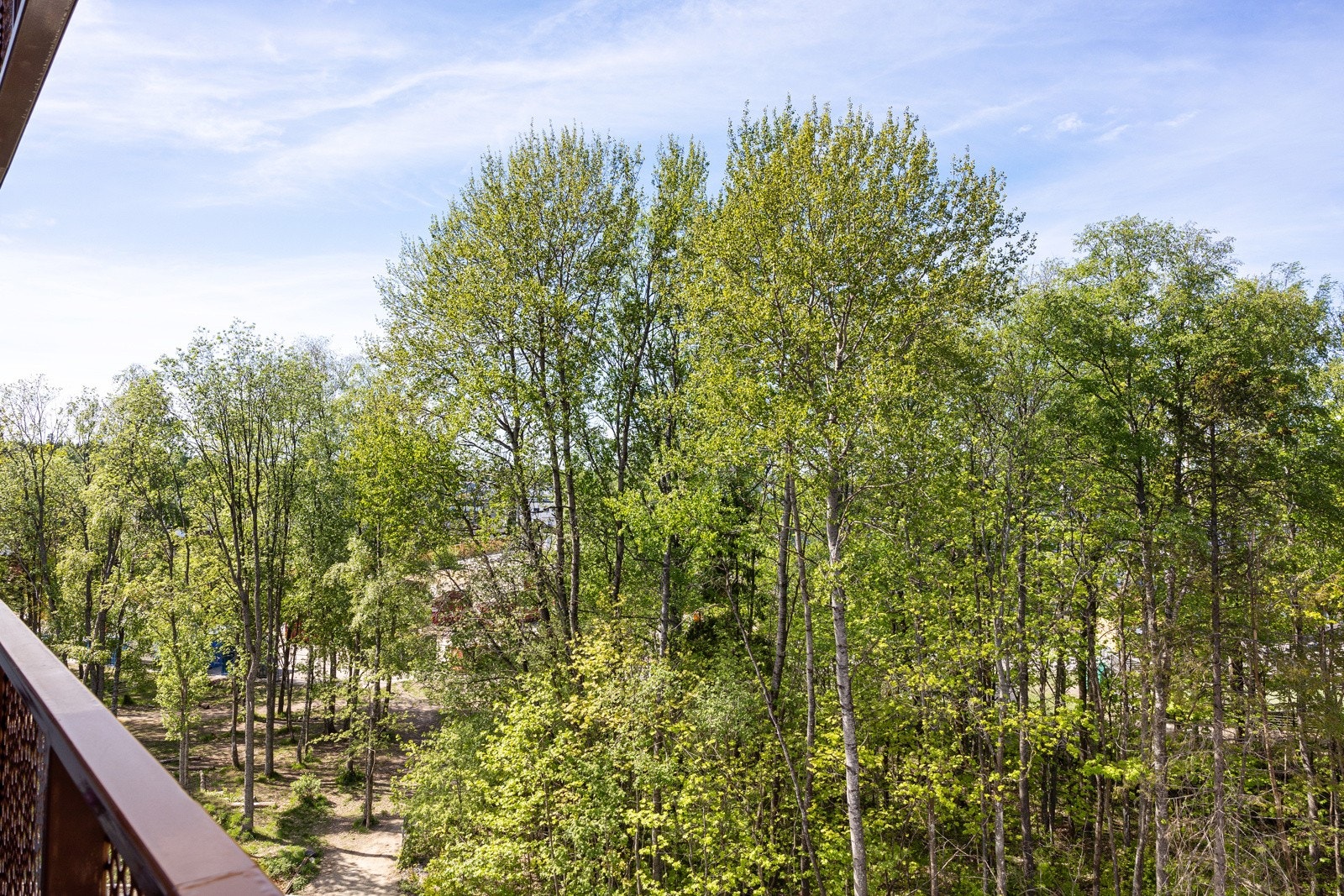 Utsikt mot natur og påkostede utearealer fra leilighetens to balkonger. Galleribilde