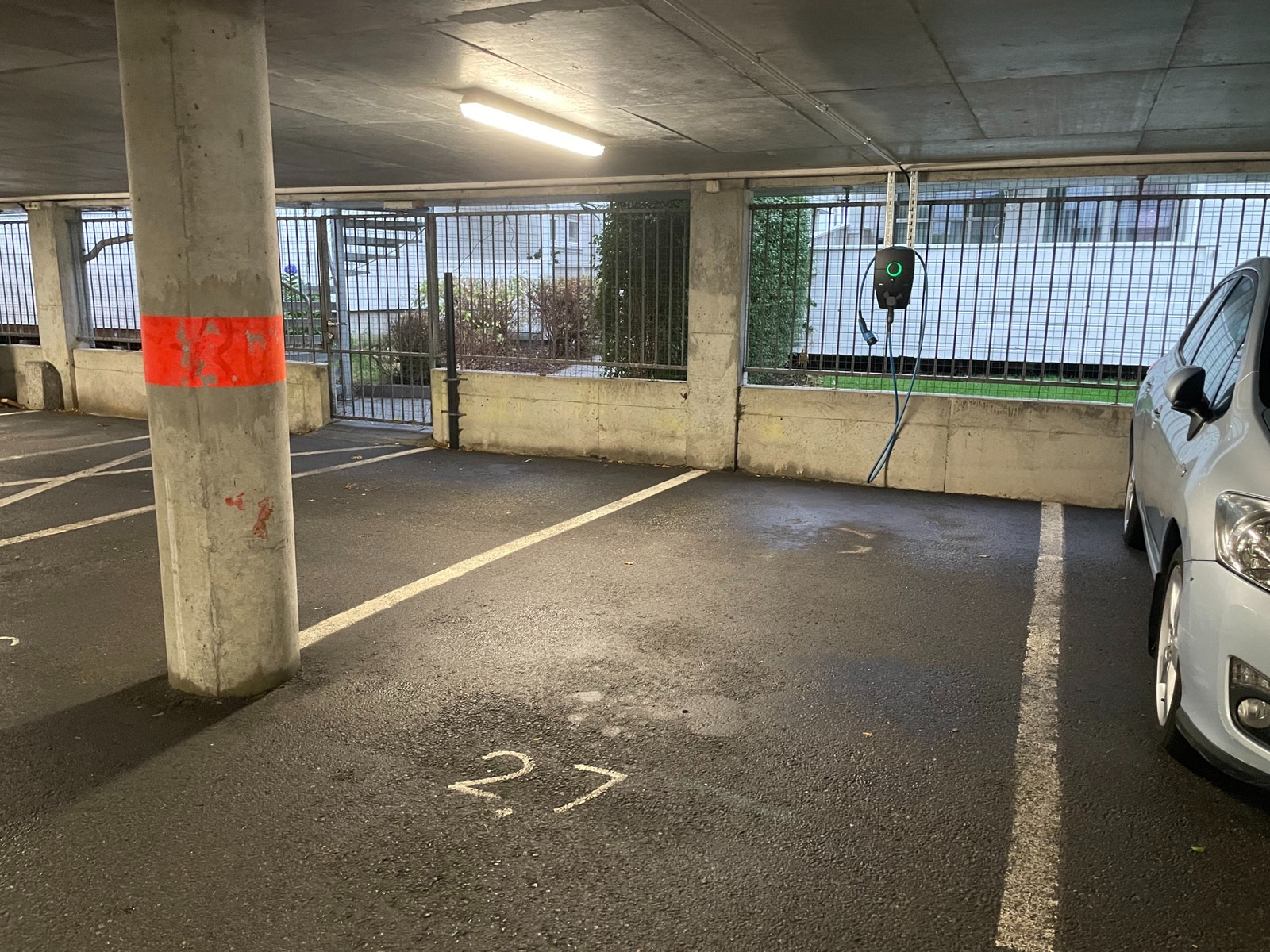 Parkeringplass i garasje med elbillader. Galleribilde