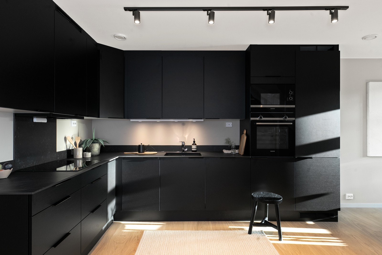 Kjøkkenet er som tatt rett ut fra et interiørmagasin. Det er en stram og moderne kjøkkeninnredning fra JKE med integrert mikro, stekeovn, kjøleskap og platetopp. Galleribilde