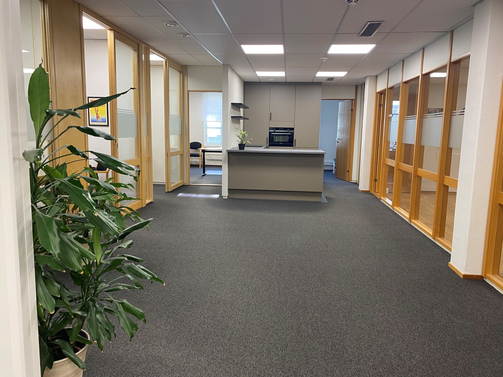 Gang med kontorer/møterom på sidene og kjøkken i enden Galleribilde