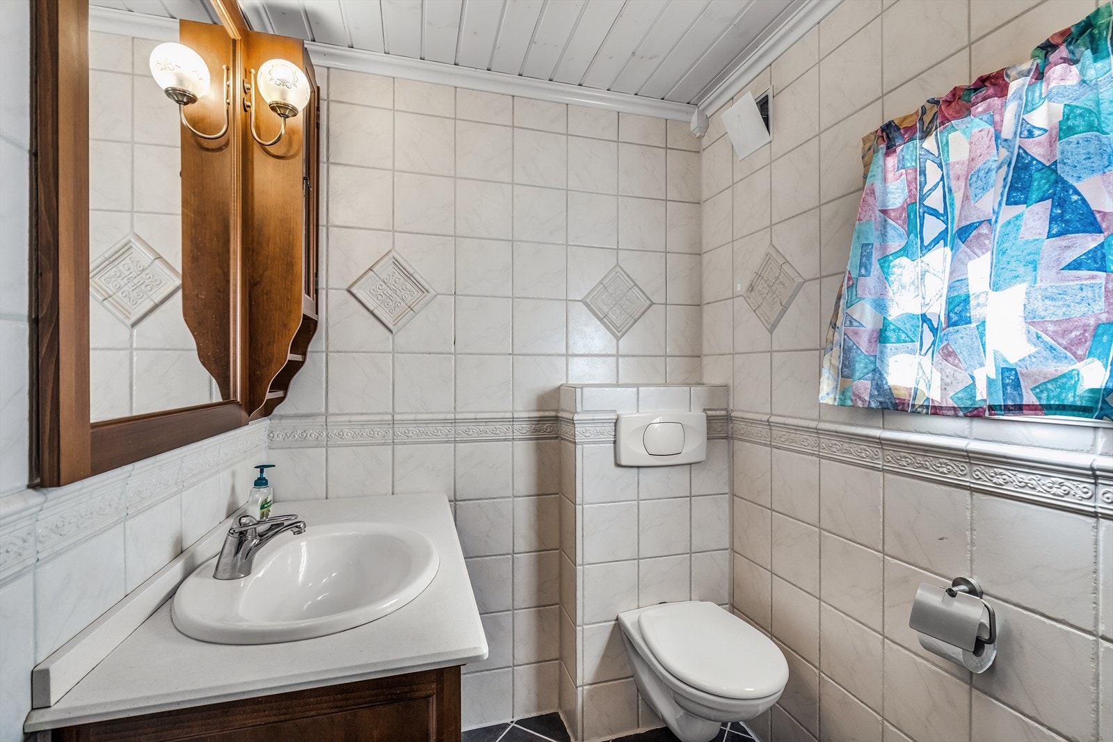 Baderommet ble ifølge tidligere salgsoppgave oppgradert i 2005, og fremstår som et funksjonelt og ryddig rom med tidløse materialvalg. Rommet er innredet med servantskap, dusjkabinett og veggmontert toalett som gir et moderne og plassbesparende preg. Galleribilde