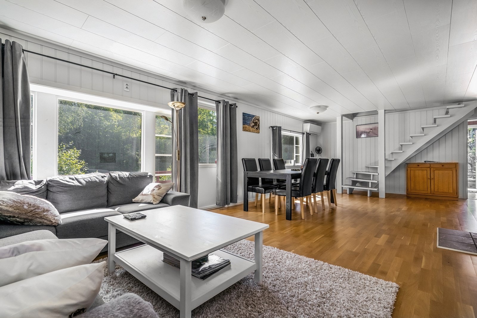 Stuen har god plass til både en romslig sofagruppe og et stort spisebord - perfekt for både hverdag og sosiale sammenkomster. Galleribilde