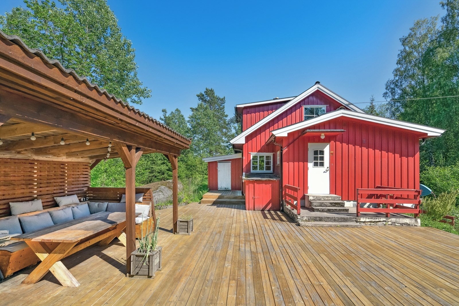 Adkomsten til boligen skjer via en stor og solrik terrasse. Ved inngangsdøren er det støpte trappetrinn og et lite overbygg som gir god skjerming mot vær og vind, og skaper en lun og innbydende entré. Galleribilde