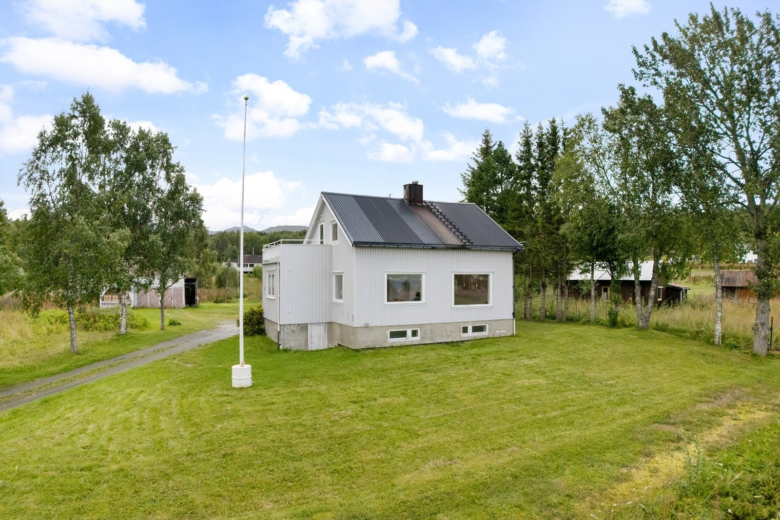 Eneboligen har ei stor og åpen tomt med gressplen - perfekt for lek, hageprosjekter eller uteplass Galleribilde