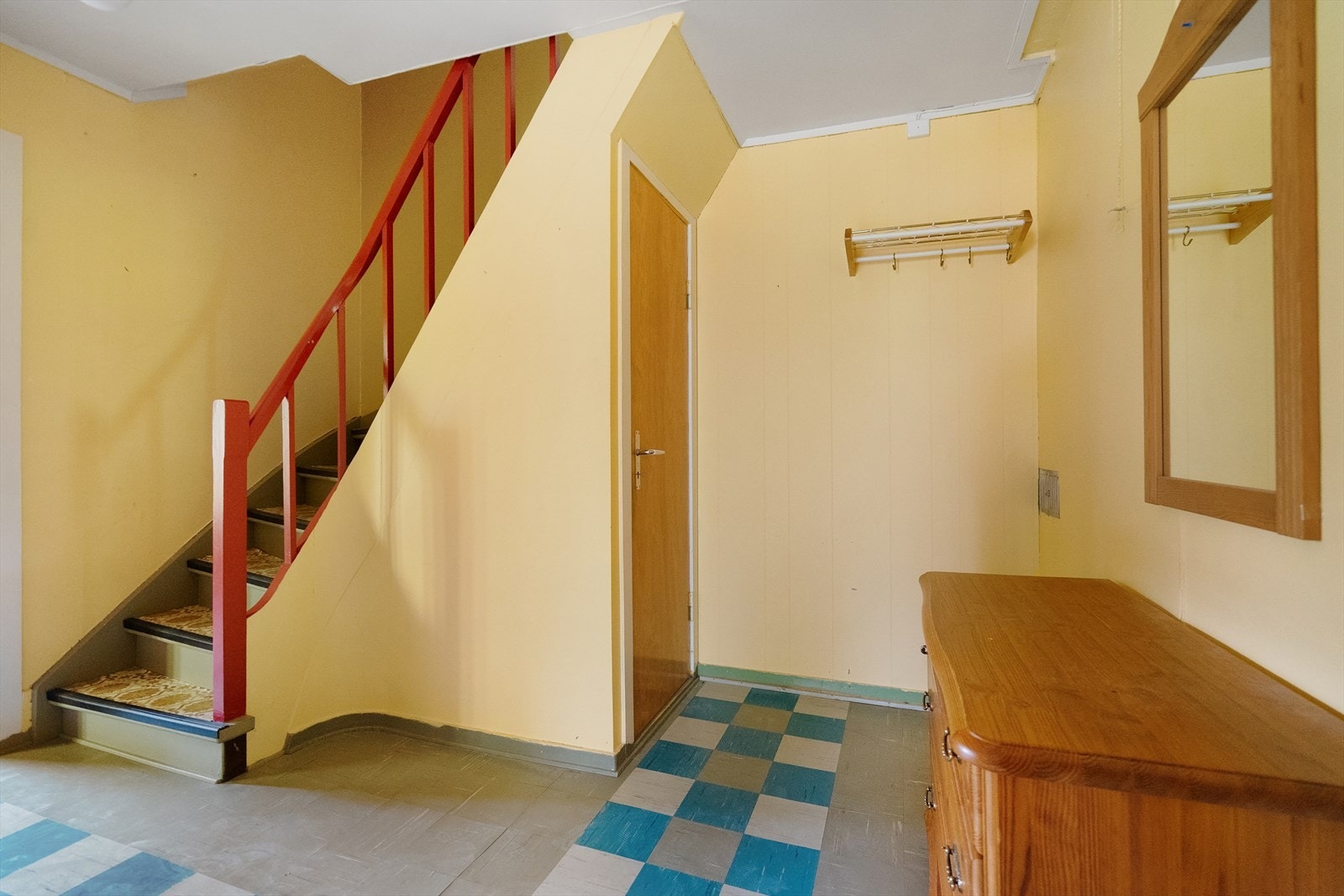 Romslig hall med oppbevaringsmuligheter og trapp som leder opp til boligens andre etasje Galleribilde