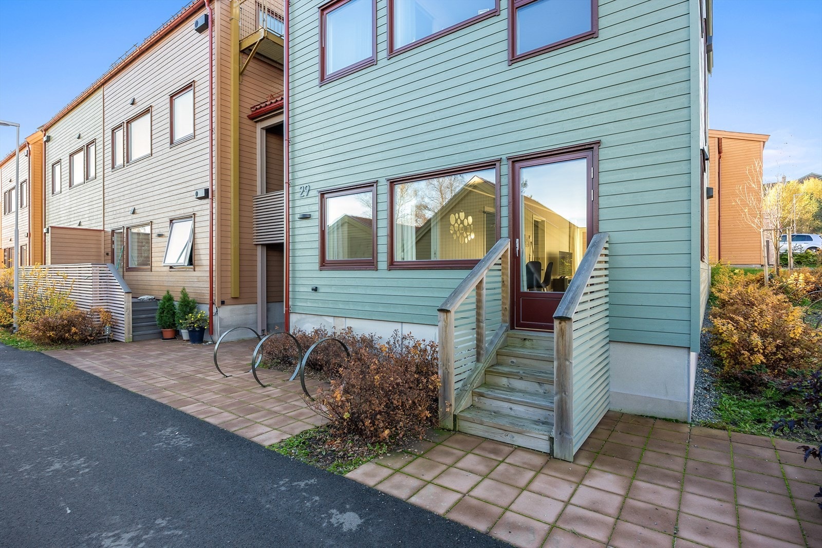 Det er terrassedør fra kjøkkensiden med trappeadkomst ut til opparbeidet fellesareal på fremsiden av boligen. Galleribilde