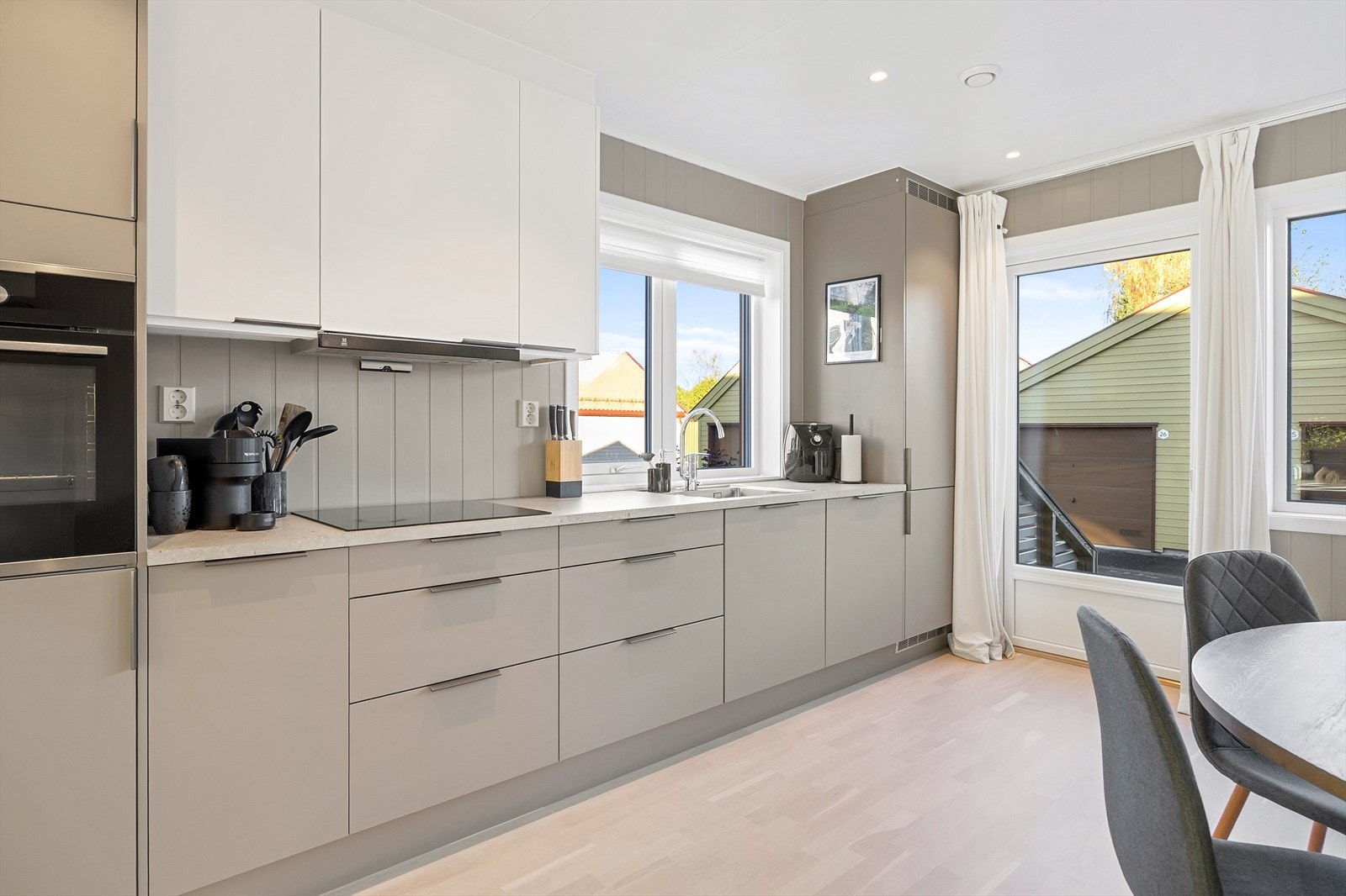 Kjøkkeninnredningen har grå og hvite glatte fronter, samt laminert benkeplate. Galleribilde