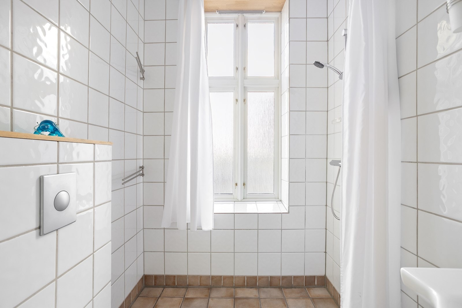 Flislagt bad med gulvvarme, stort vindu og opplegg til vaskemaskin Galleribilde