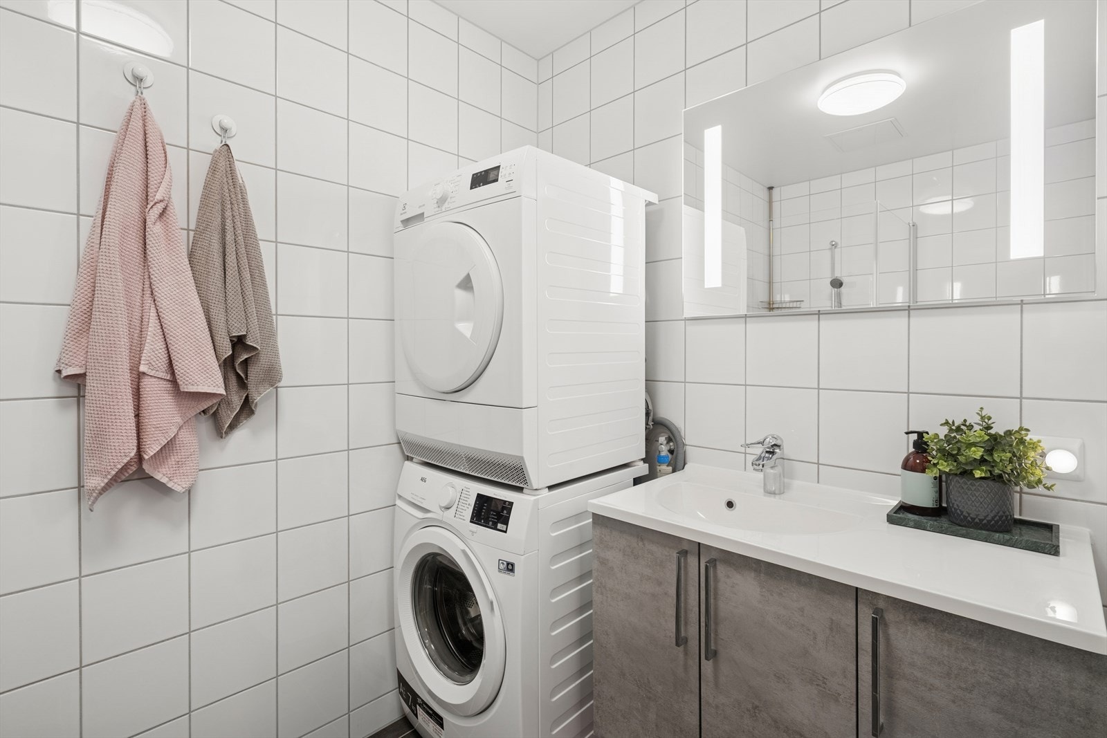 Badet er ellers utstyrt med dusjhjørne, vegghengt toalett og baderomsinnredning med nedfelt servant. I tillegg har man opplegg for vaskemaskin og plass til tørketrommel. Galleribilde