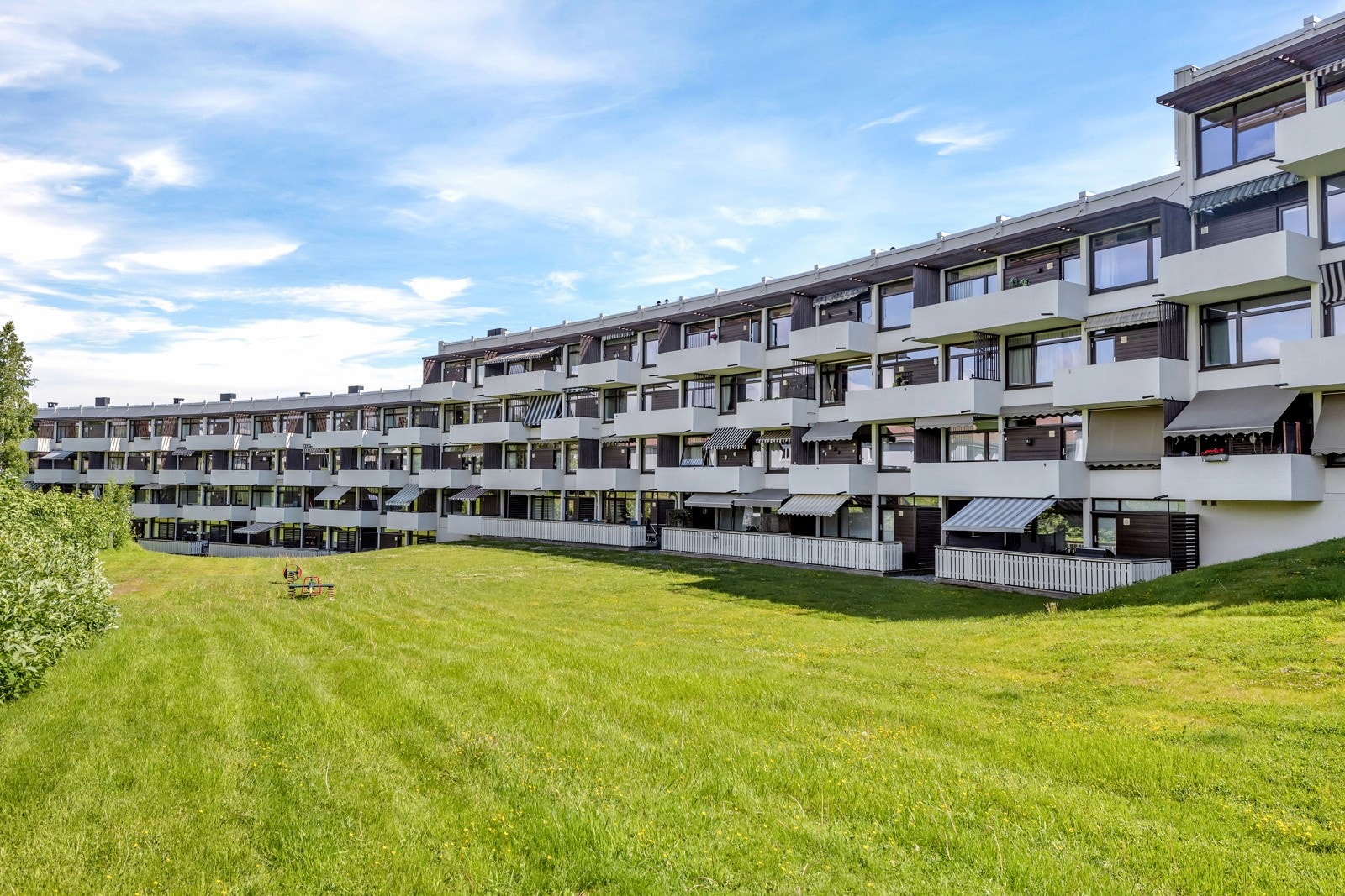 Fellestomten er opparbeidet med asfaltere internveier og parkeringsareal, lekeplass, plenareal, felles sittegrupper og felles sykkelparkering. Galleribilde
