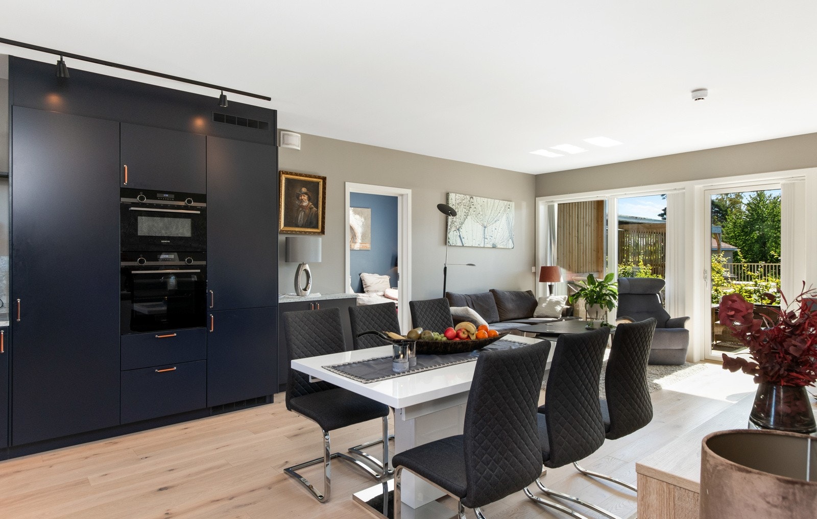 Kjøkkenet er moderne og elegant, plassert i en romslig L-form, i åpen løsning til stuen Galleribilde