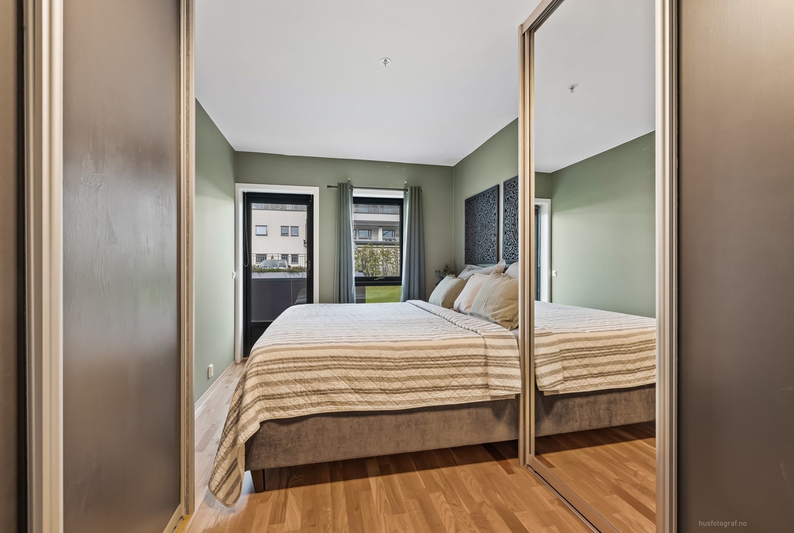Soverom 2 med utgang til hyggelig terrasseplatting som ligger i tilknytning til felles hageareal. Galleribilde