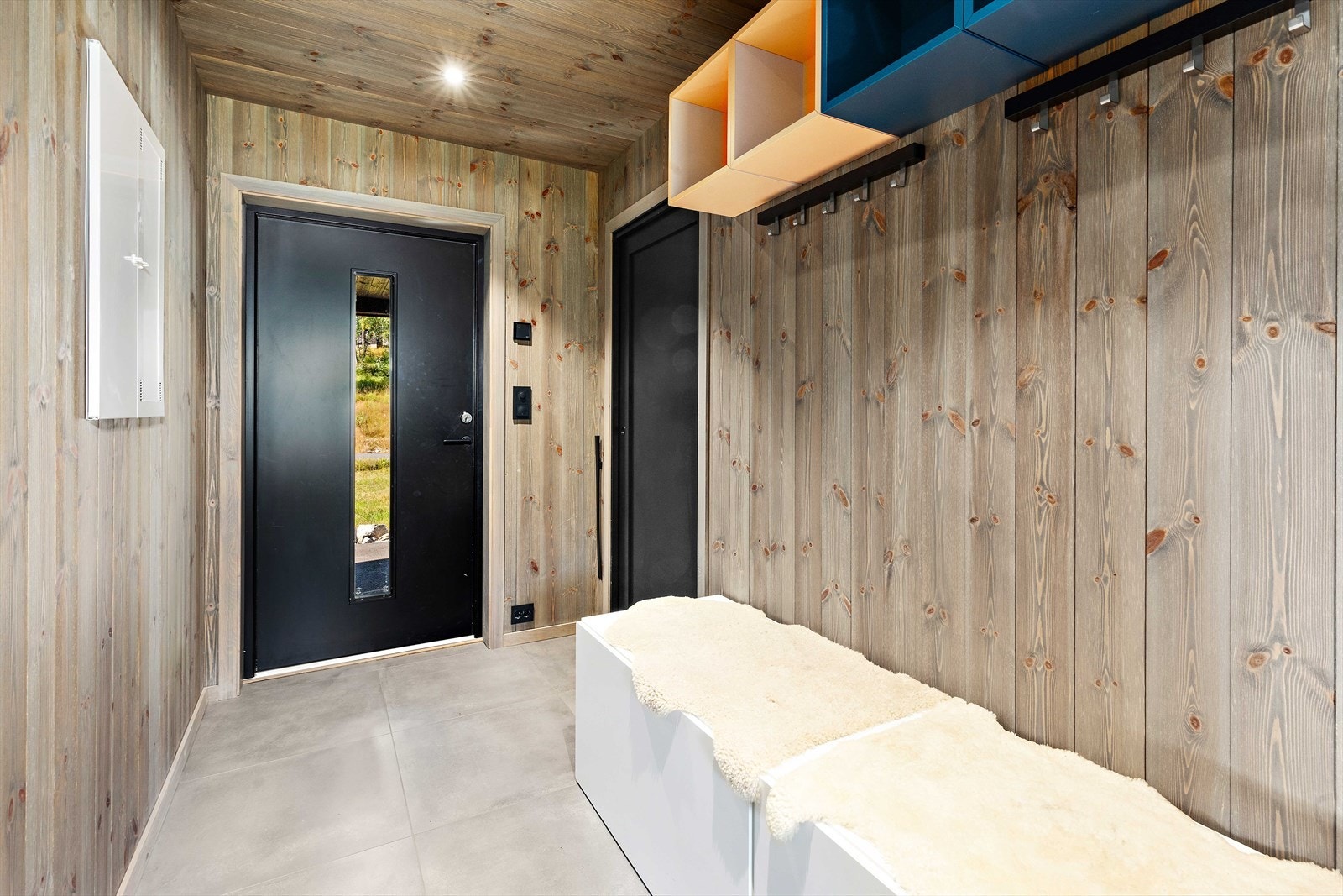 Praktisk entre med fliser på gulv med varmekabler samt en bod/tørkerom til oppbevaring av yttertøy, skiutstyr ol. Galleribilde