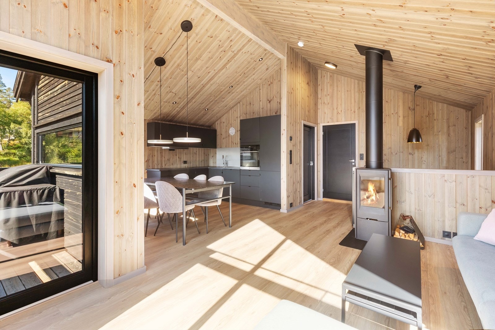 Utgang til terrasse til venstre. Her er vedovn for oppvarming og downlights i tak. Galleribilde