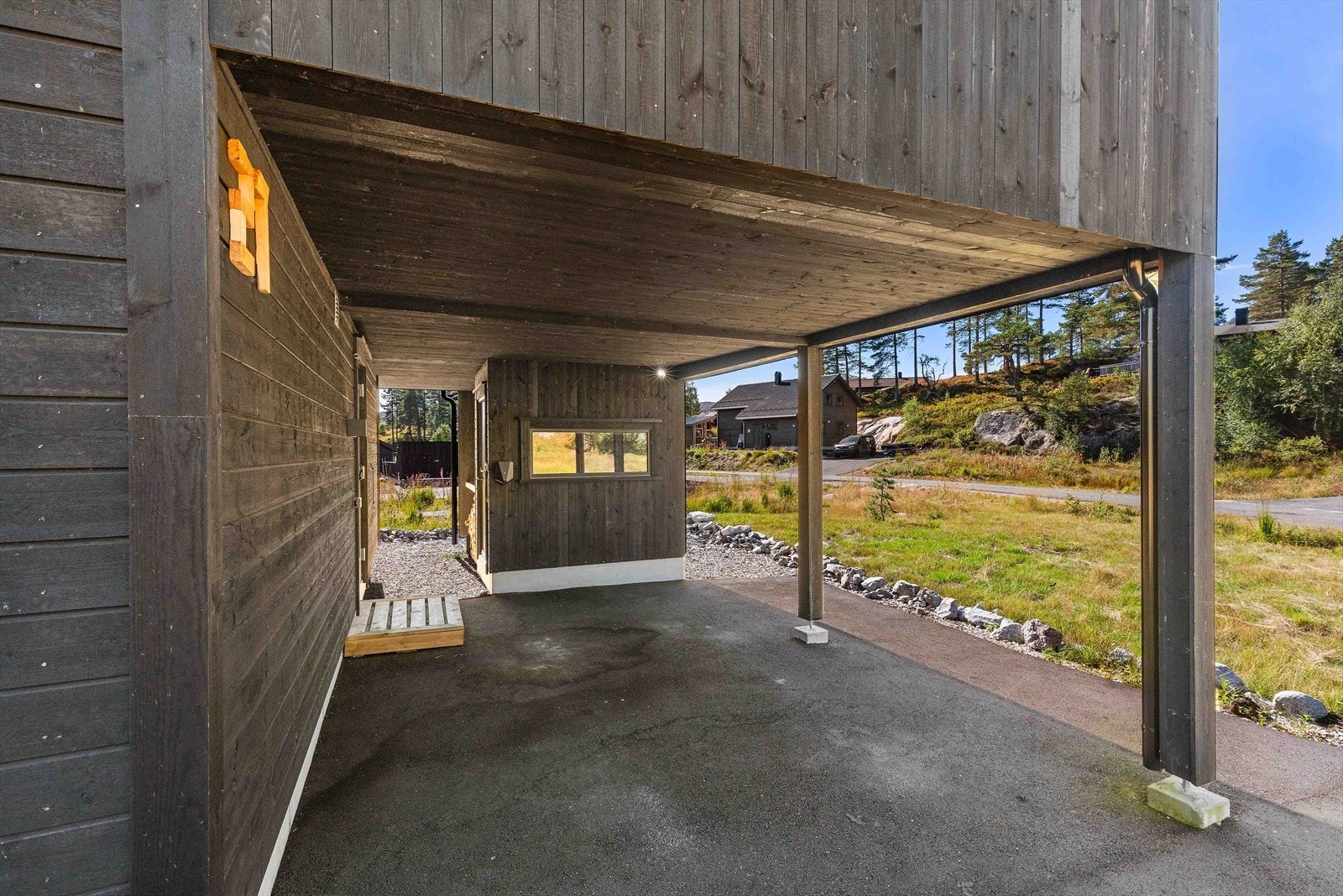 Carport hvor inngangsparti er til venstre. Her er også en utvendig bod. Galleribilde