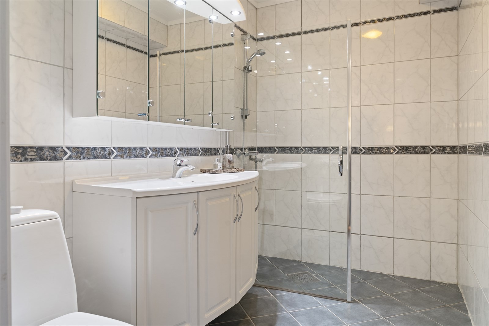 Det lyse og funksjonelle badet er helfliset og har behagelig gulvvarme Galleribilde